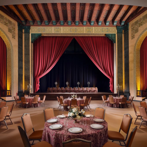 The Bonstelle's elegant event space adorned with crimson velvet curtains and stunning architectural accents.